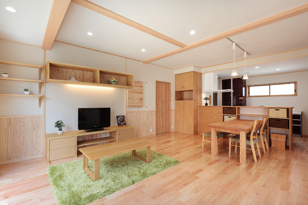 Foto di un soggiorno etnico aperto con pareti bianche, parquet chiaro, TV autoportante e pavimento beige