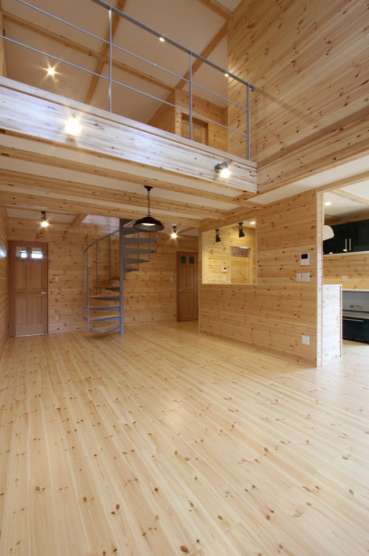 Großes, Offenes Industrial Wohnzimmer mit beiger Wandfarbe, hellem Holzboden, Kaminofen, Kaminumrandung aus Holzdielen, freistehendem TV, beigem Boden, freigelegten Dachbalken und vertäfelten Wänden in Fukuoka