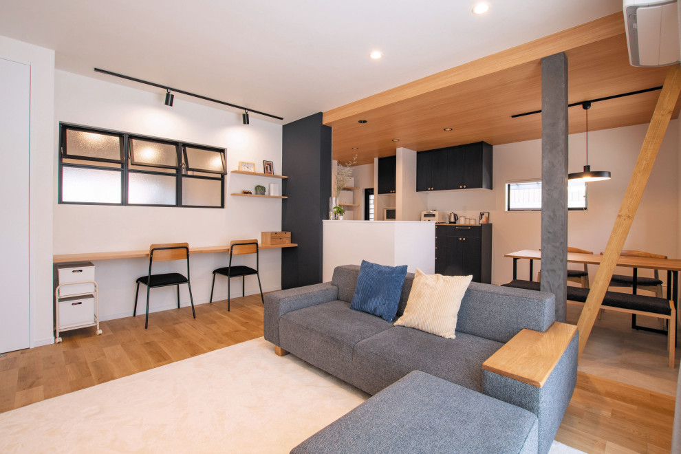 Offenes Skandinavisches Wohnzimmer ohne Kamin mit weißer Wandfarbe, braunem Holzboden, freistehendem TV, braunem Boden, Tapetendecke und Tapetenwänden in Sonstige
