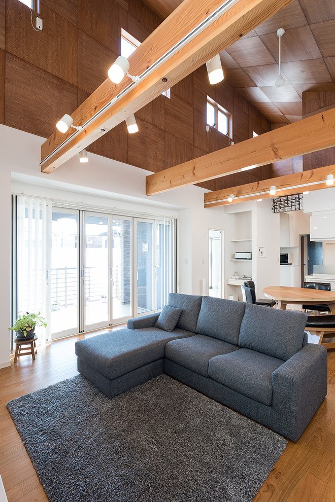 Diseño de salón abierto contemporáneo de tamaño medio sin chimenea con paredes blancas y suelo de madera en tonos medios