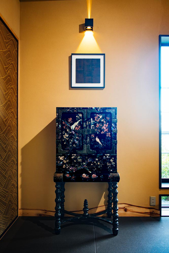 Asiatisk inredning av ett stort allrum med öppen planlösning, med ett finrum, beige väggar, tatamigolv, en dubbelsidig öppen spis, en spiselkrans i trä och svart golv