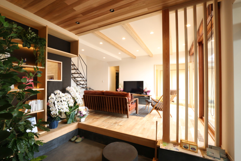 Großes Klassisches Wohnzimmer mit brauner Wandfarbe, hellem Holzboden, beigem Boden und freistehendem TV in Sonstige