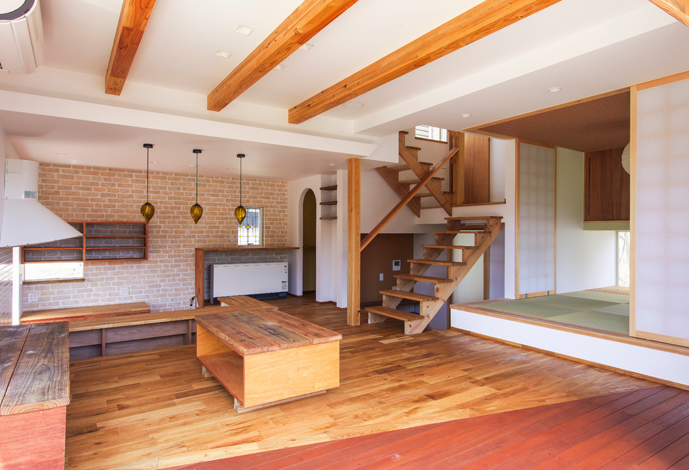 Immagine di un soggiorno etnico con pareti bianche e pavimento in legno massello medio