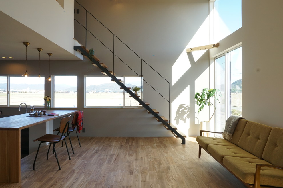 Idéer för att renovera ett funkis vardagsrum, med vita väggar, ljust trägolv och beiget golv