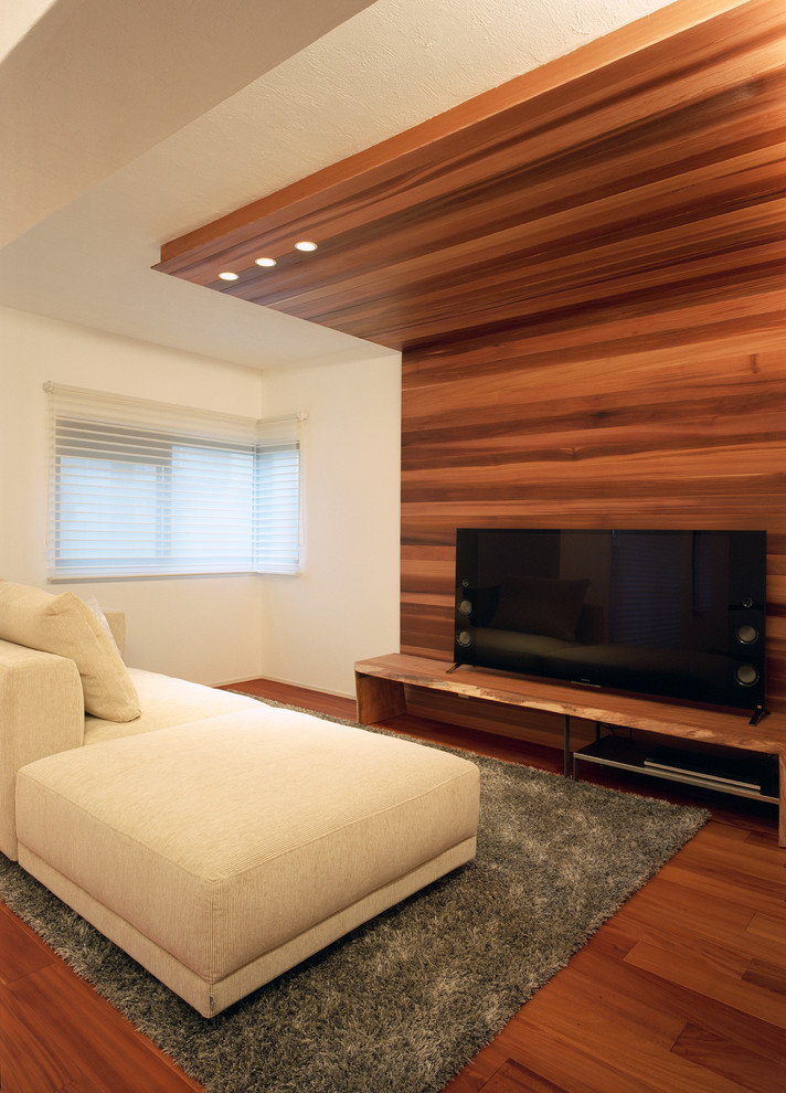 Cette image montre un salon minimaliste avec un mur multicolore, un sol en bois brun, un téléviseur indépendant et un sol marron.