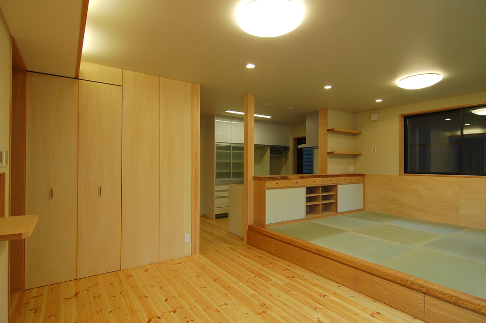 Open concept tatami floor and green floor living room photo in Other with beige walls and no fireplace