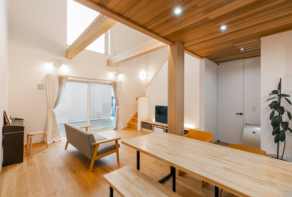 Immagine di un soggiorno nordico con pareti bianche, parquet chiaro e soffitto in legno