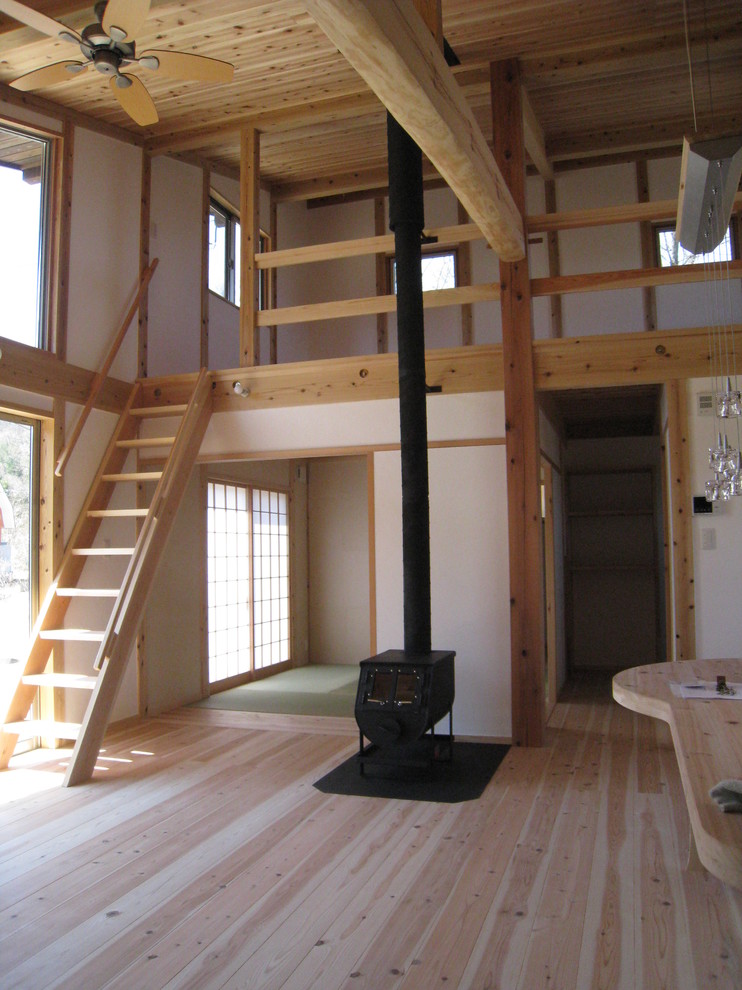 Idéer för ett litet asiatiskt vardagsrum, med vita väggar, ljust trägolv, en öppen vedspis, en spiselkrans i gips och beiget golv