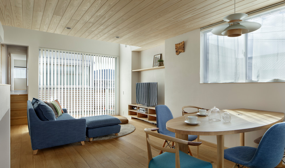 Diseño de salón nórdico con paredes blancas, suelo de madera en tonos medios y suelo marrón
