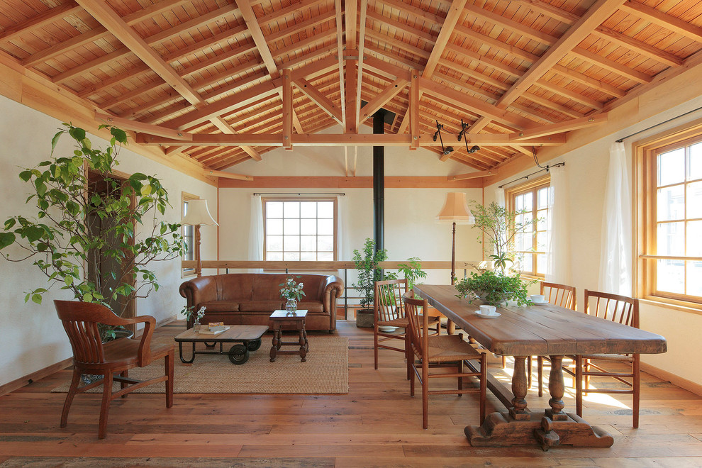 Ejemplo de salón abierto de estilo de casa de campo con paredes blancas, suelo de madera en tonos medios, estufa de leña y suelo marrón