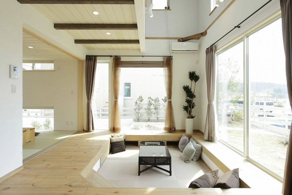 Foto på ett lantligt vardagsrum, med vita väggar, ljust trägolv och beiget golv
