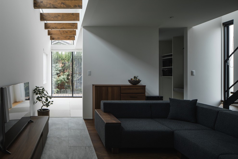 Diseño de salón abierto minimalista de tamaño medio con paredes blancas, suelo de baldosas de porcelana, televisor independiente y suelo gris