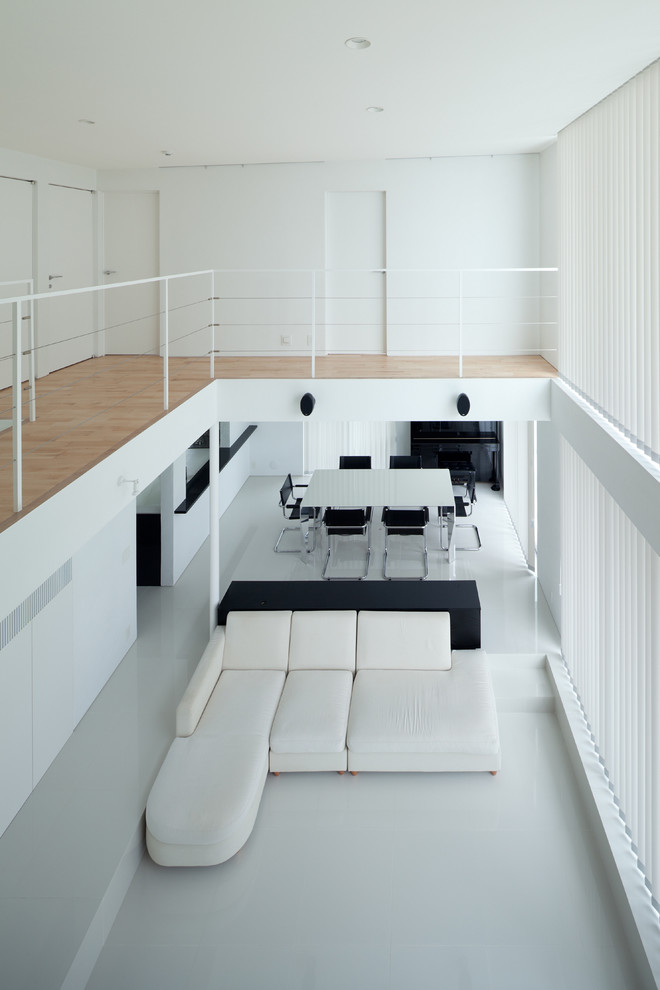 Modelo de salón abierto minimalista grande con paredes blancas, suelo de baldosas de cerámica, televisor independiente y suelo blanco