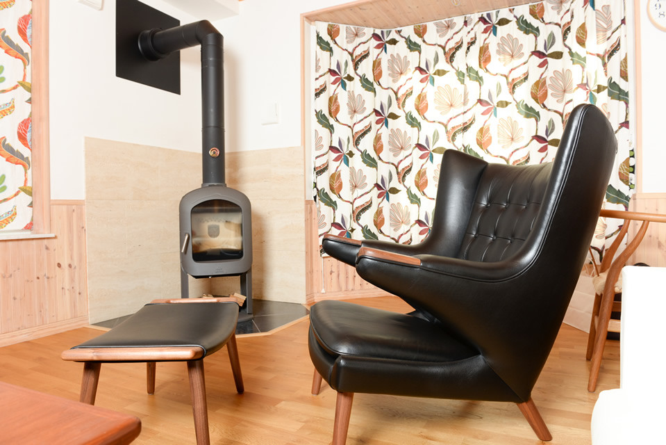 Modelo de salón abierto escandinavo de tamaño medio con paredes blancas, estufa de leña, marco de chimenea de baldosas y/o azulejos y televisor independiente