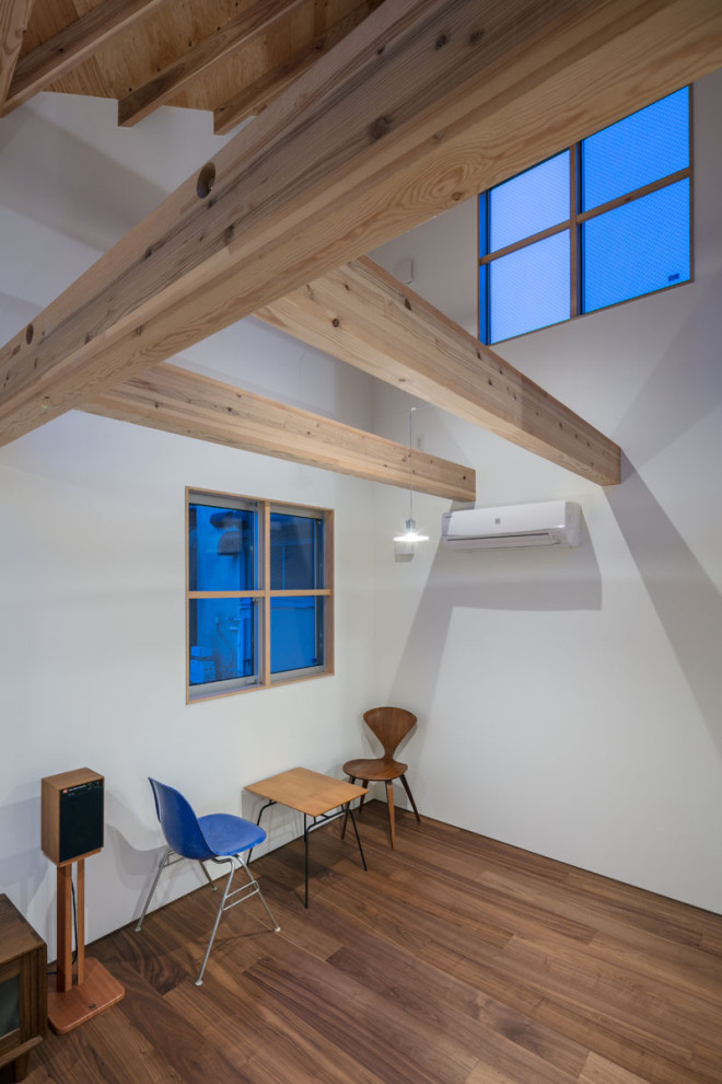 Foto de salón tipo loft minimalista pequeño sin chimenea y televisor con paredes blancas, suelo de contrachapado y suelo marrón