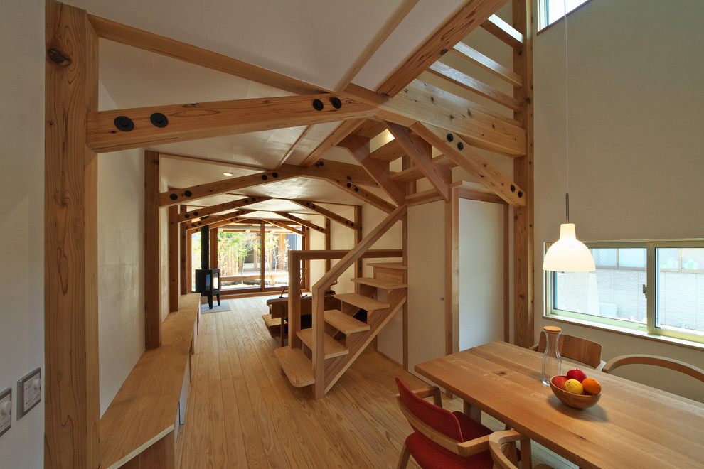 Esempio di un soggiorno etnico aperto con pareti bianche, pavimento in legno massello medio e stufa a legna