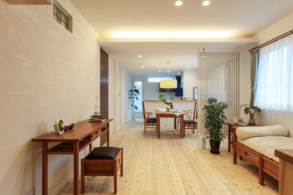 Mittelgroßes, Offenes Nordisches Wohnzimmer mit weißer Wandfarbe, hellem Holzboden und beigem Boden in Sonstige