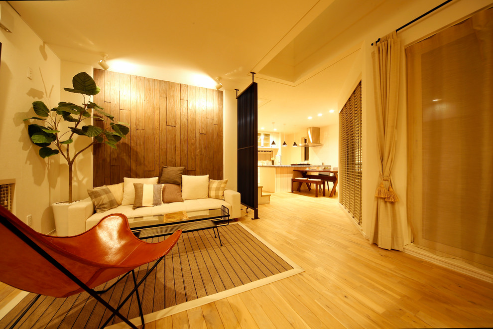Пример оригинального дизайна: гостиная комната в восточном стиле с бежевыми стенами, светлым паркетным полом и коричневым полом