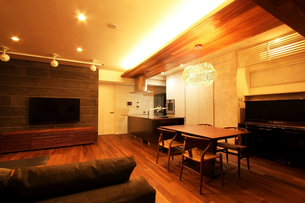 Bild på ett funkis vardagsrum, med vita väggar, mörkt trägolv, en väggmonterad TV och brunt golv