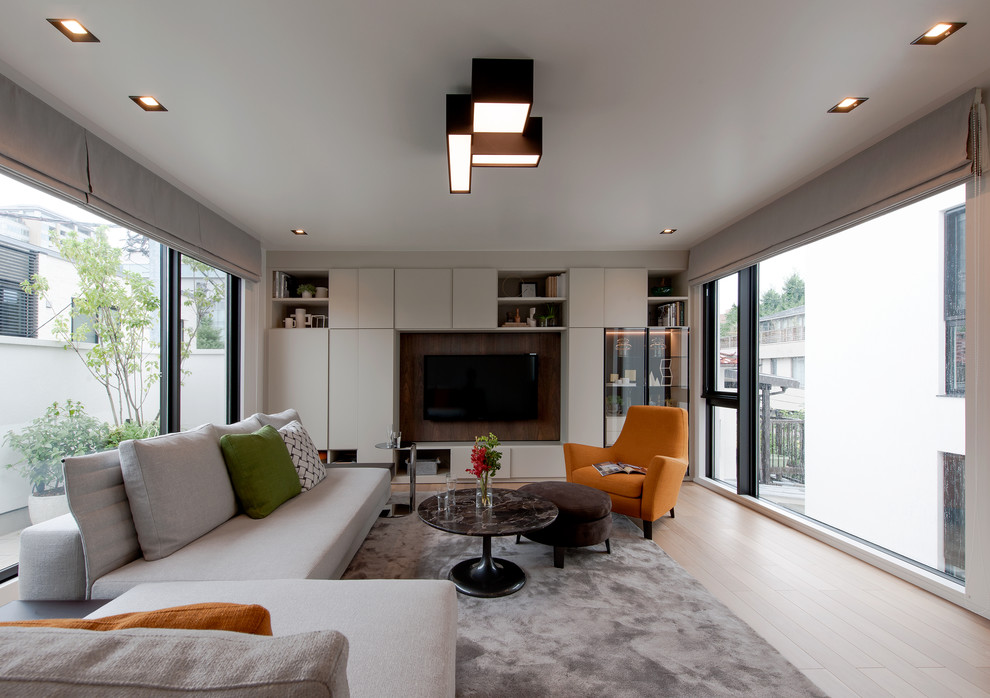 Idéer för ett modernt separat vardagsrum, med ett finrum, beige väggar, ljust trägolv, en väggmonterad TV och beiget golv