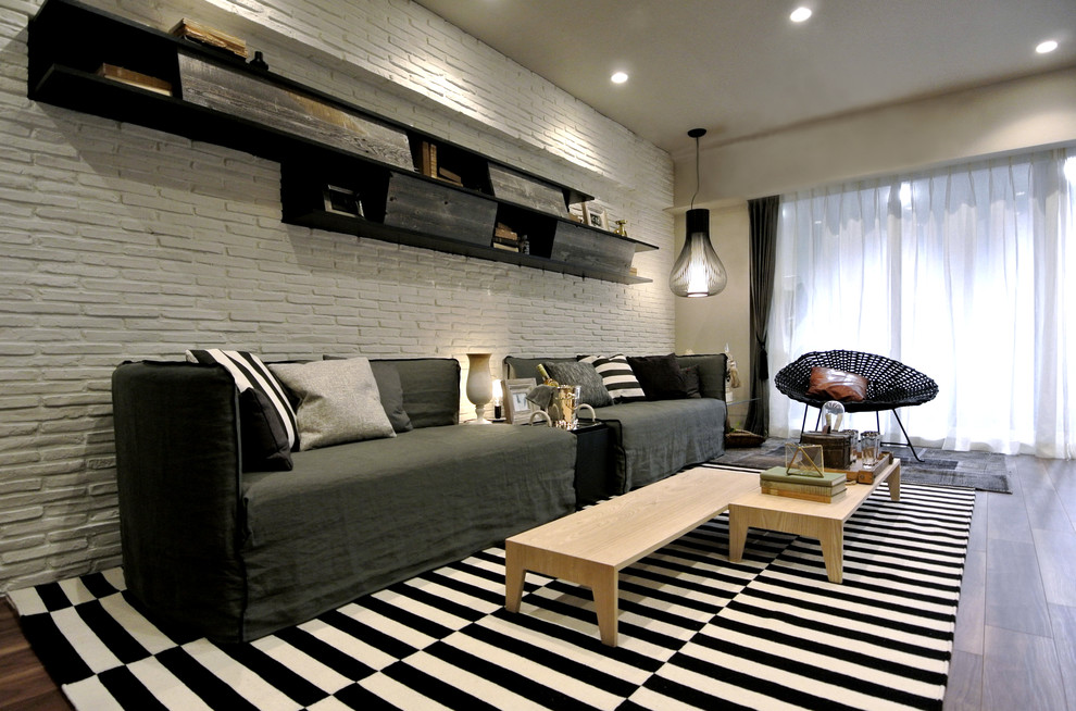 Aménagement d'un petit salon contemporain avec un mur blanc et un sol en bois brun.