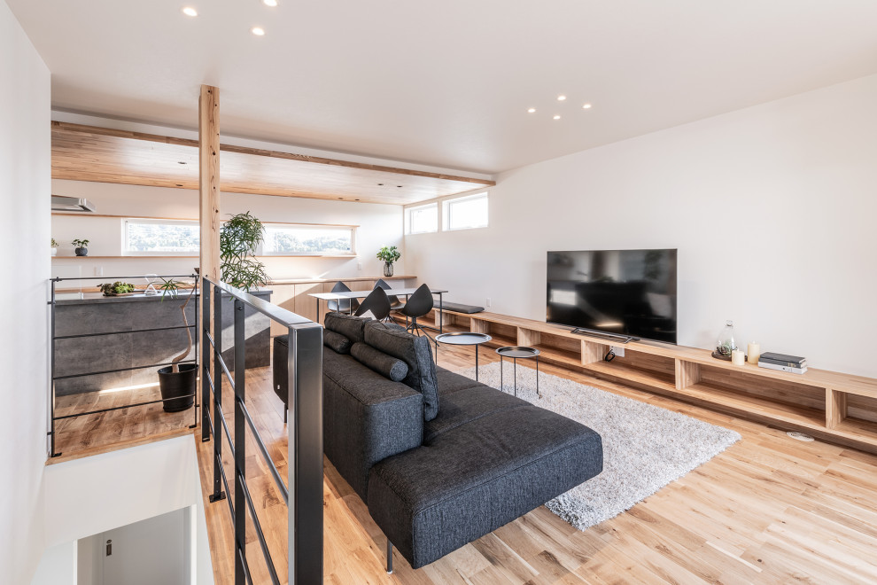 Imagen de salón abierto asiático de tamaño medio con suelo de madera en tonos medios, suelo beige, papel pintado, paredes blancas y televisor independiente