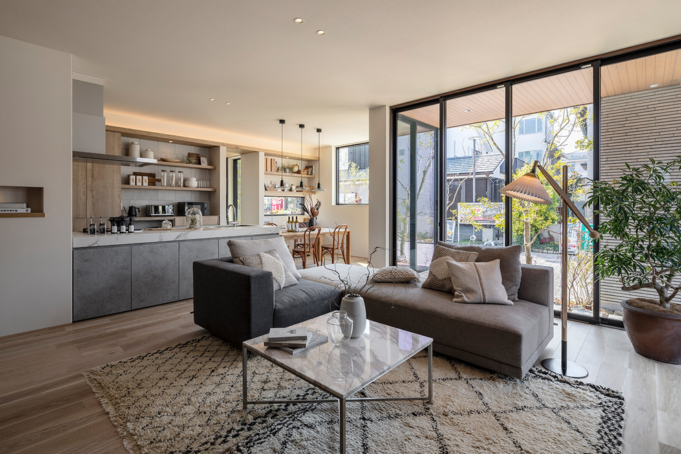 Immagine di un soggiorno design aperto con pareti bianche, pavimento in legno massello medio e pavimento marrone
