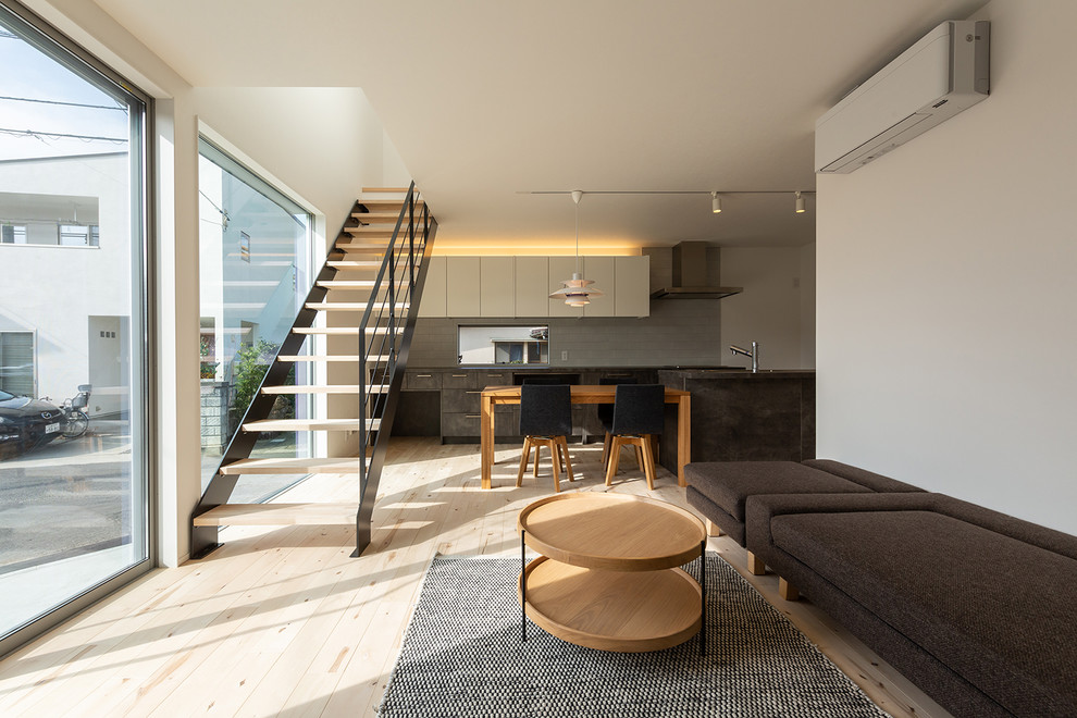 This is an example of a modern living room in Tokyo with light hardwood flooring and beige floors.
