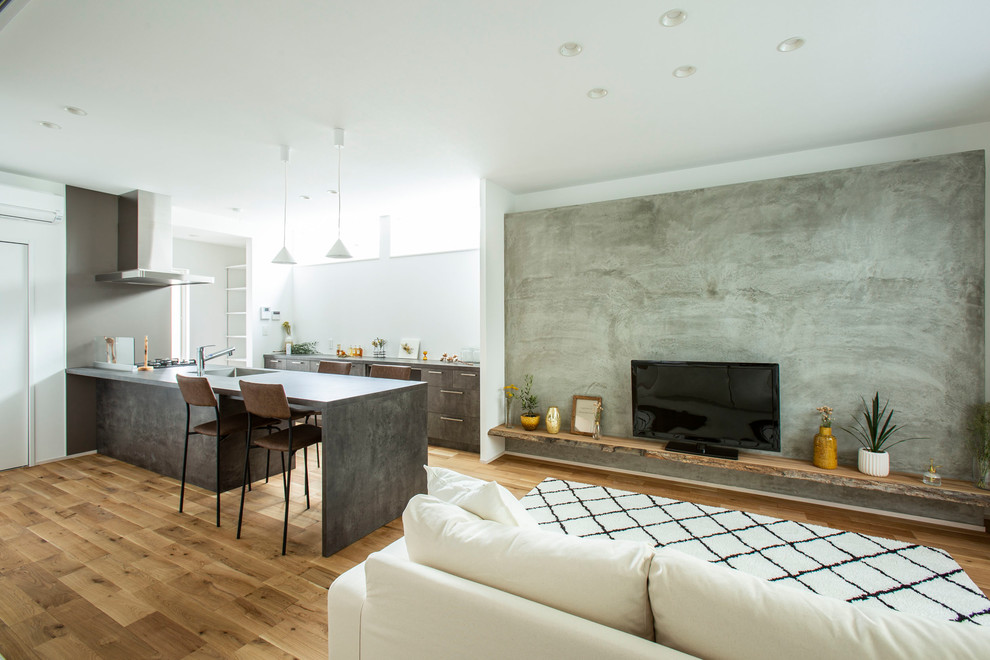 Imagen de salón abierto minimalista de tamaño medio con suelo de madera en tonos medios, suelo marrón, paredes multicolor y televisor independiente