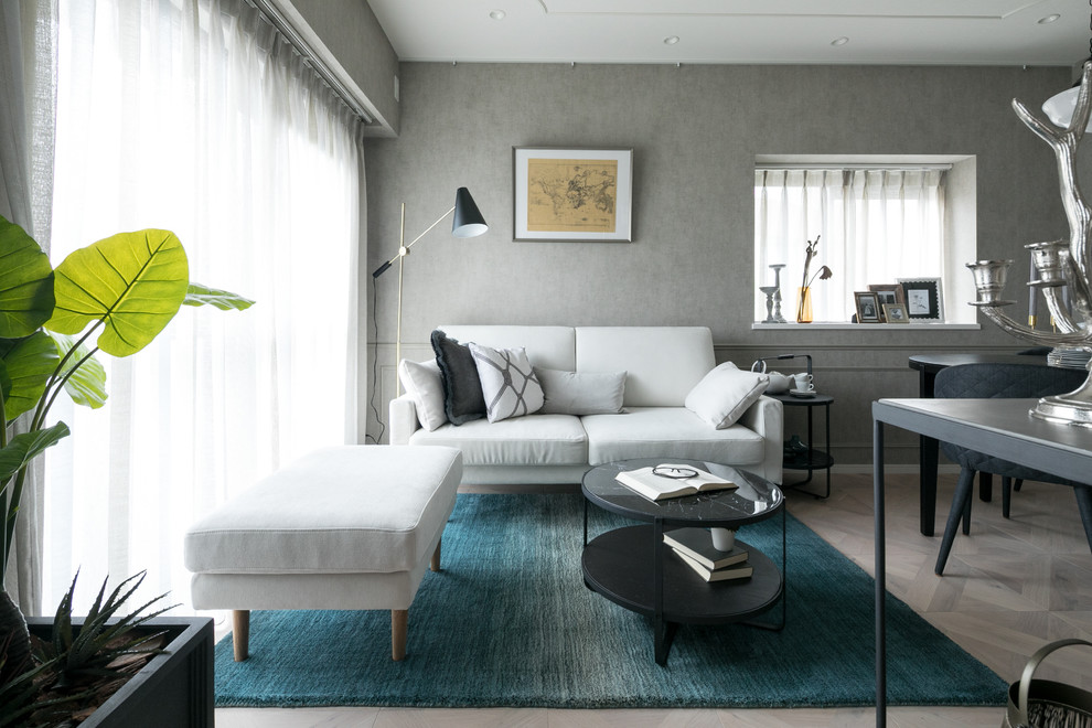 Immagine di un soggiorno minimalista con pareti grigie, pavimento in legno verniciato e pavimento grigio