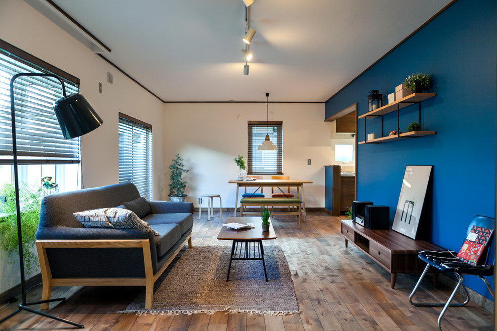 Immagine di un soggiorno minimal chiuso con sala formale, pareti blu, pavimento in legno massello medio e pavimento marrone