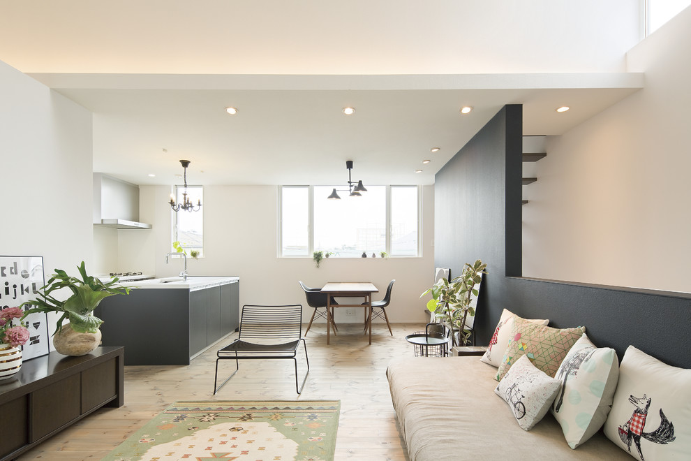 Offenes Nordisches Wohnzimmer mit hellem Holzboden, beigem Boden und weißer Wandfarbe in Sonstige