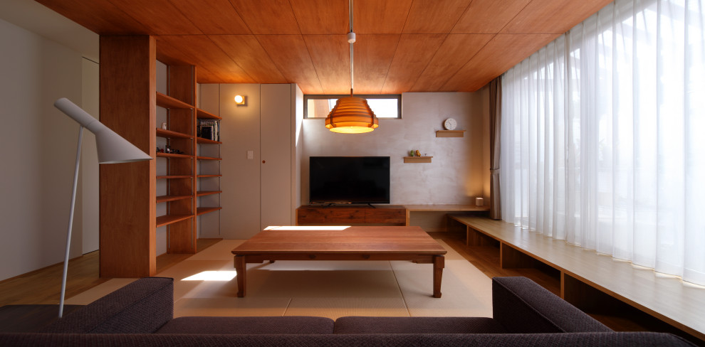 Mittelgroßes, Offenes Modernes Wohnzimmer ohne Kamin mit grauer Wandfarbe, Tatami-Boden, freistehendem TV und beigem Boden in Fukuoka