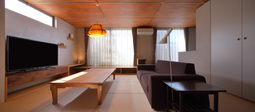 Cette image montre un salon minimaliste de taille moyenne et ouvert avec un mur gris, un sol de tatami, aucune cheminée, un téléviseur indépendant et un sol beige.