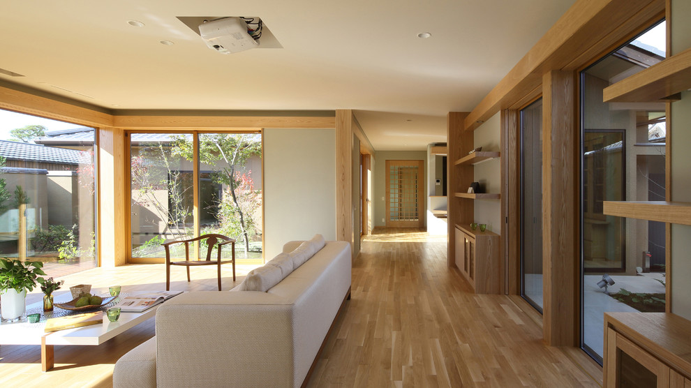 Esempio di un soggiorno etnico con pareti grigie, pavimento in legno massello medio e pavimento marrone