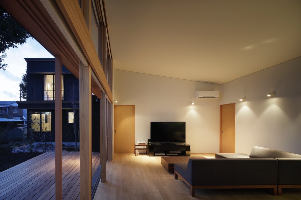 Großes, Offenes Asiatisches Wohnzimmer mit weißer Wandfarbe, Sperrholzboden, Kaminofen, gefliester Kaminumrandung, freistehendem TV und beigem Boden in Tokio