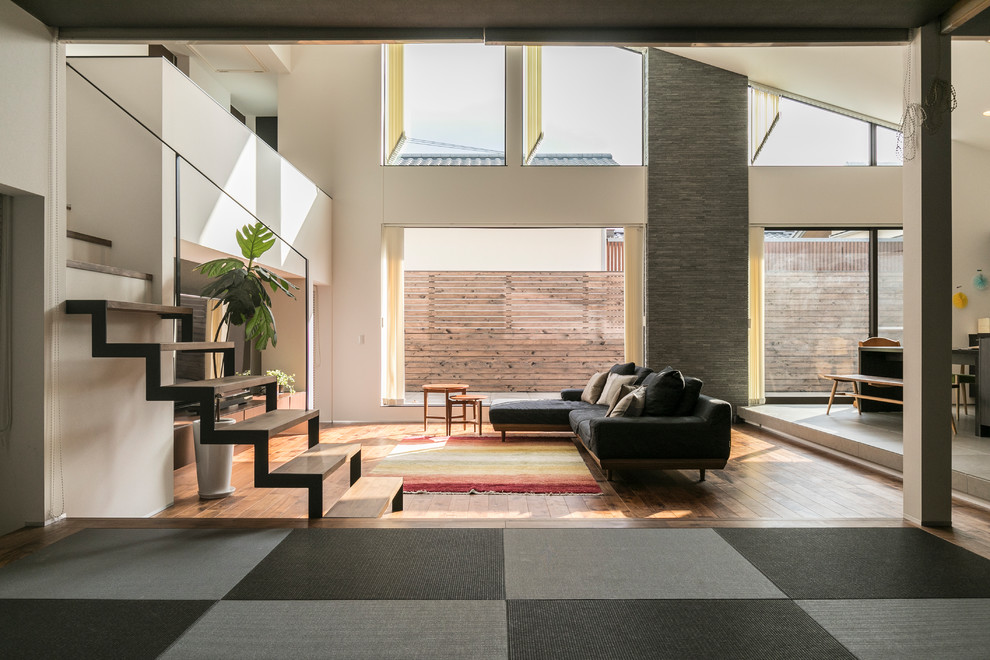 Idee per un grande soggiorno etnico aperto con pareti bianche, pavimento in legno massello medio, TV autoportante e pavimento marrone