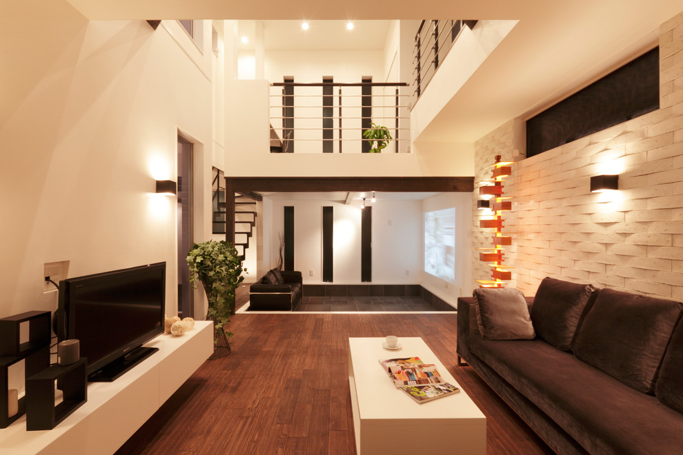 На фото: открытая гостиная комната в стиле модернизм с белыми стенами, темным паркетным полом и коричневым полом