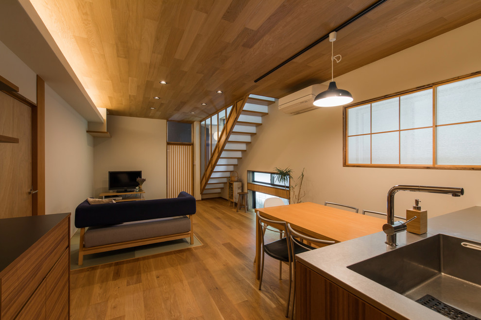 Idee per un soggiorno scandinavo aperto con pareti bianche, pavimento in legno massello medio, TV autoportante e pavimento marrone