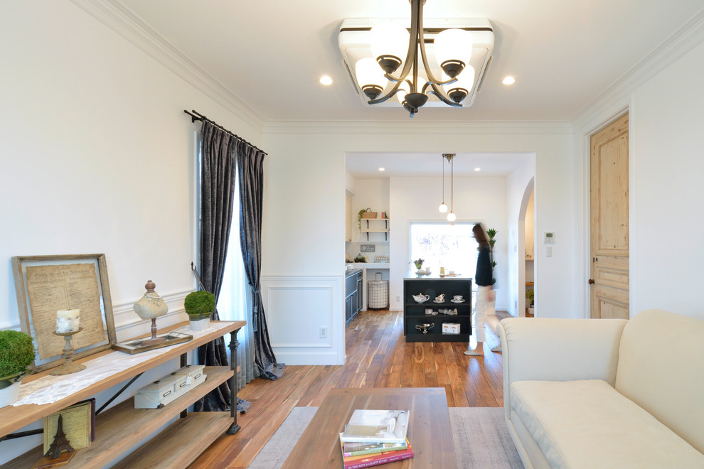 Esempio di un soggiorno classico aperto con pareti bianche, pavimento in legno massello medio e pavimento marrone