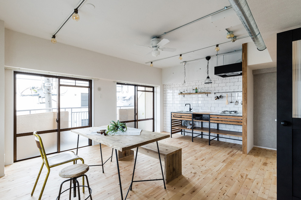 Immagine di un soggiorno industriale aperto con pareti bianche e pavimento in legno massello medio