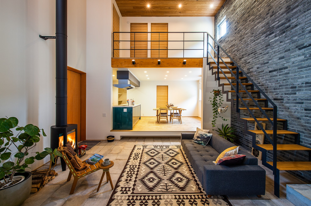 Foto di un soggiorno minimalista aperto con pareti bianche, pavimento in cemento, stufa a legna, cornice del camino in cemento e pavimento grigio