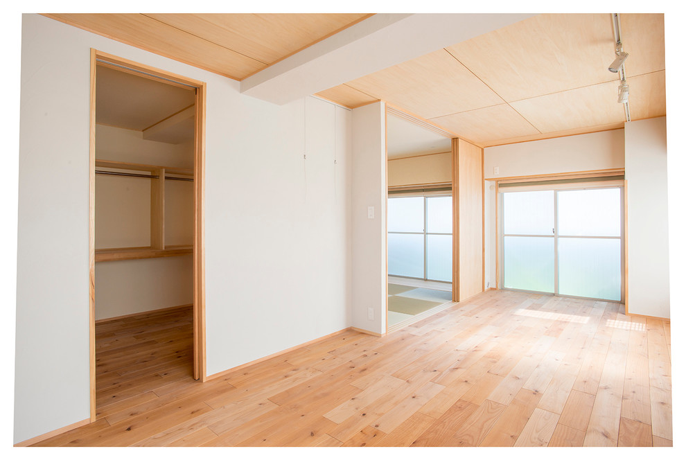 Foto di un soggiorno moderno aperto con pareti bianche, pavimento in legno massello medio e pavimento beige