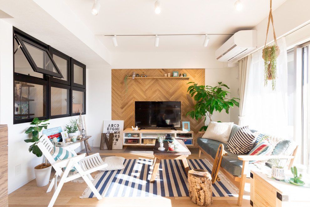 Diseño de salón abierto moderno con paredes multicolor, suelo de madera clara, televisor independiente y suelo marrón