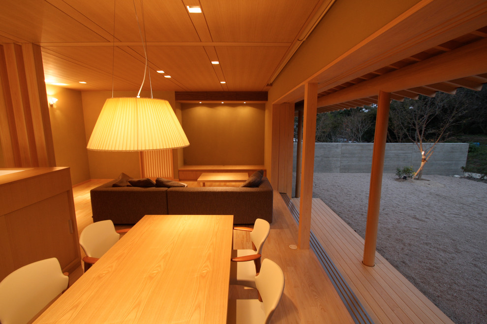 Imagen de salón abierto de estilo zen pequeño sin chimenea con paredes beige, suelo de madera clara y televisor independiente