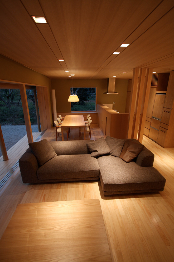 Ejemplo de salón abierto de estilo zen pequeño sin chimenea con paredes beige, suelo de madera clara y televisor independiente