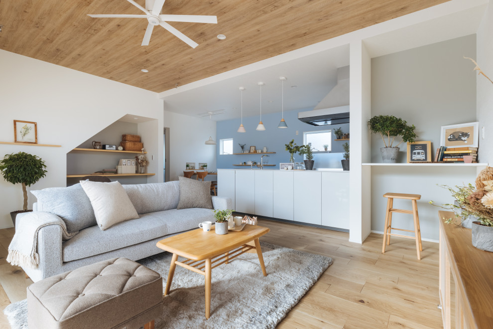 Mittelgroßes, Offenes Skandinavisches Wohnzimmer mit weißer Wandfarbe, hellem Holzboden, beigem Boden, Tapetendecke und Tapetenwänden in Sonstige