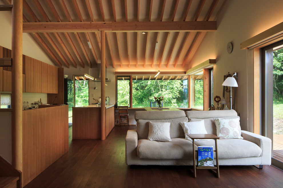 Foto de salón abierto de estilo de casa de campo sin chimenea y televisor con paredes amarillas y suelo de madera oscura