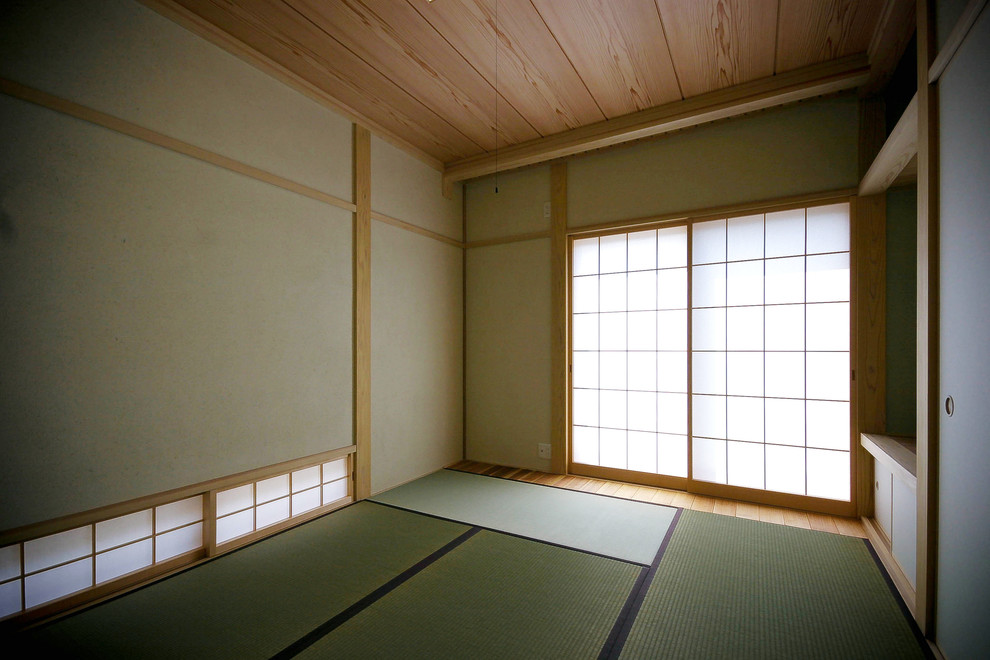 Cette photo montre un grand salon asiatique ouvert avec un mur vert, un sol de tatami et aucune cheminée.