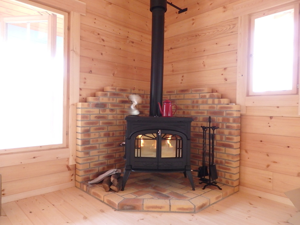 Exemple d'un salon avec un poêle à bois et un manteau de cheminée en brique.